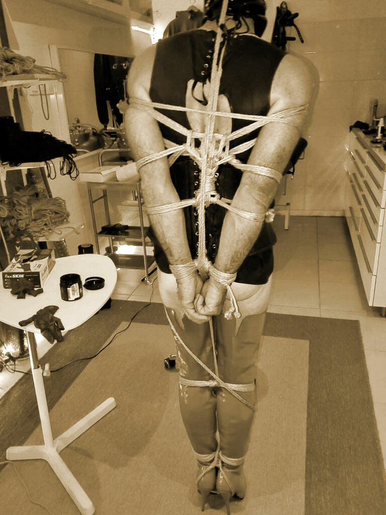 Un savant bondage de fines cordes bien serrées emprisonnent l'esclave chaussées de cuissardes